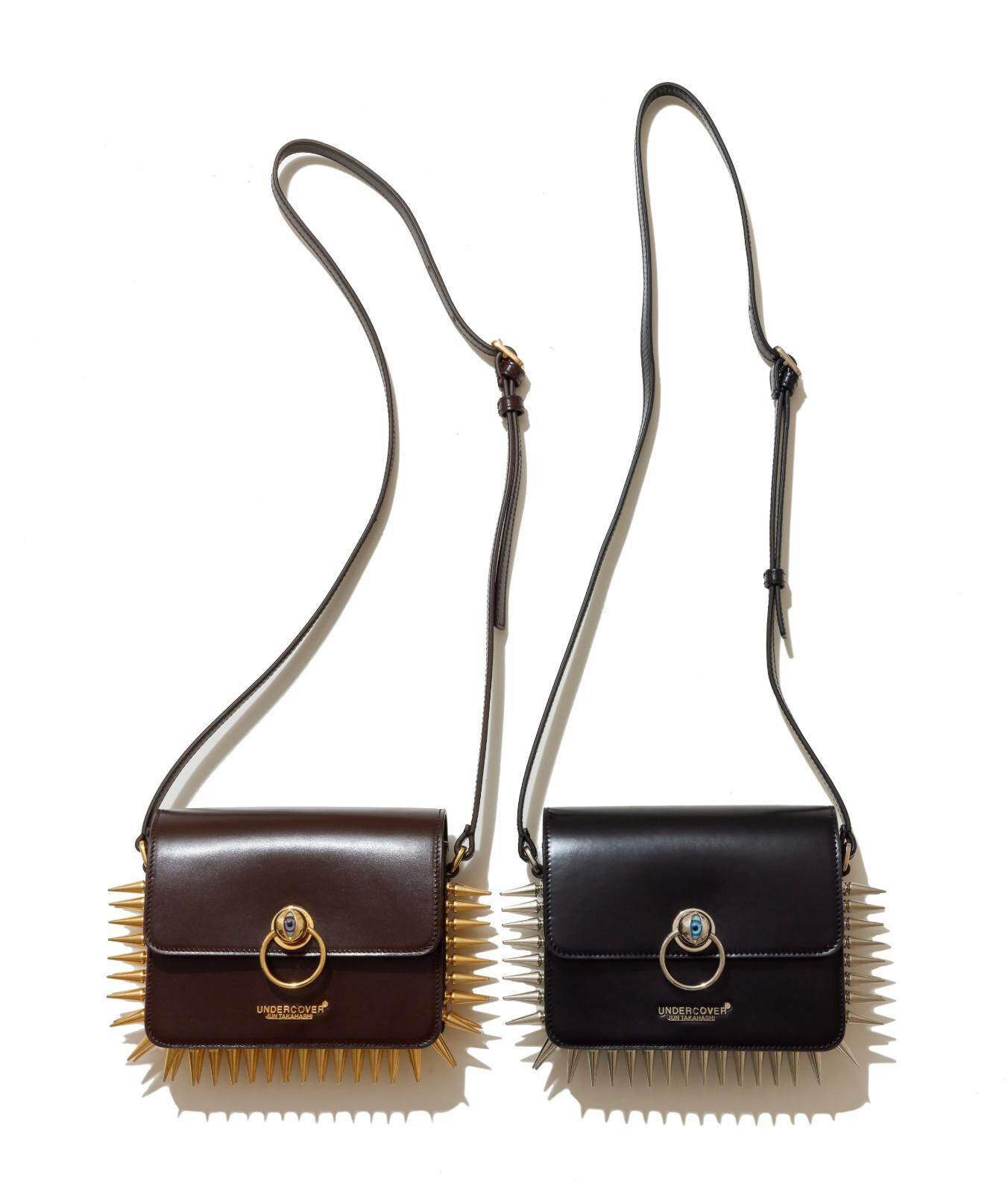 アンダーカバー“目玉”クラスプのレザーショルダーバッグ、大胆なメタル