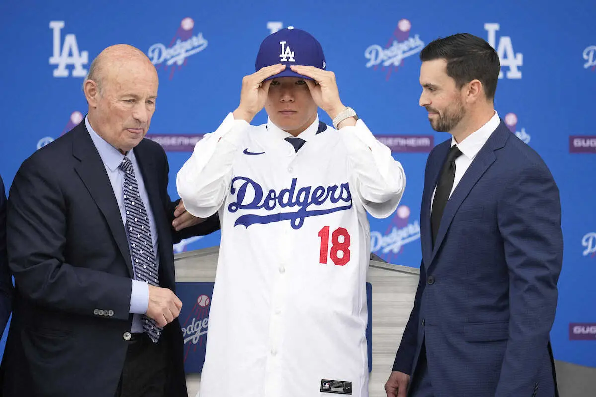 ユニホーム姿を披露した山本由伸（中）。左はスタン・カステン球団社長