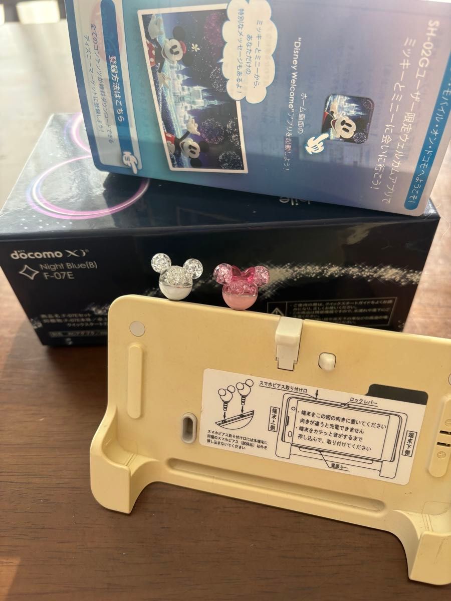 F07E docomo 卓上フォルダ イヤホンジャック スマホピアス2個 箱付き