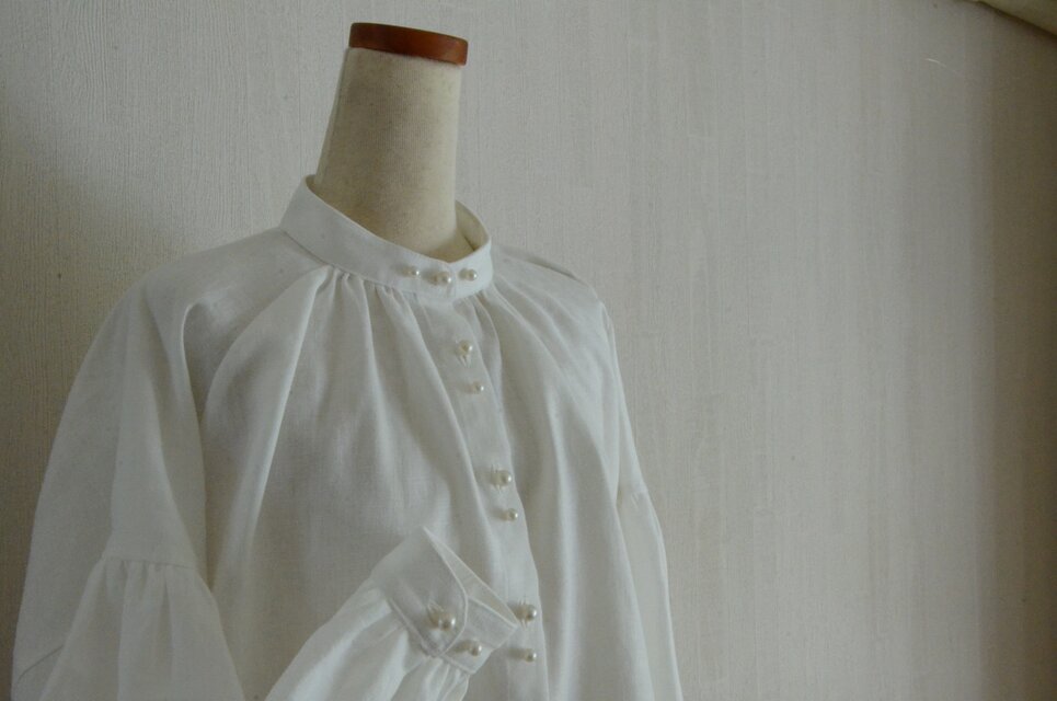 リネン100％ スタンドカラーの白ブラウス クリームパールボタン