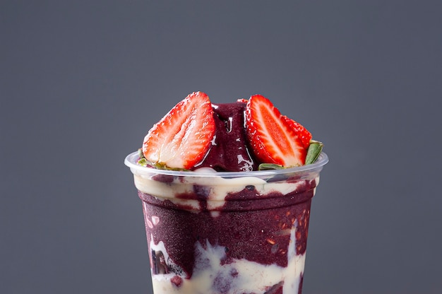 Brazilian frozen açaí in a plastic cup with condensed milk and