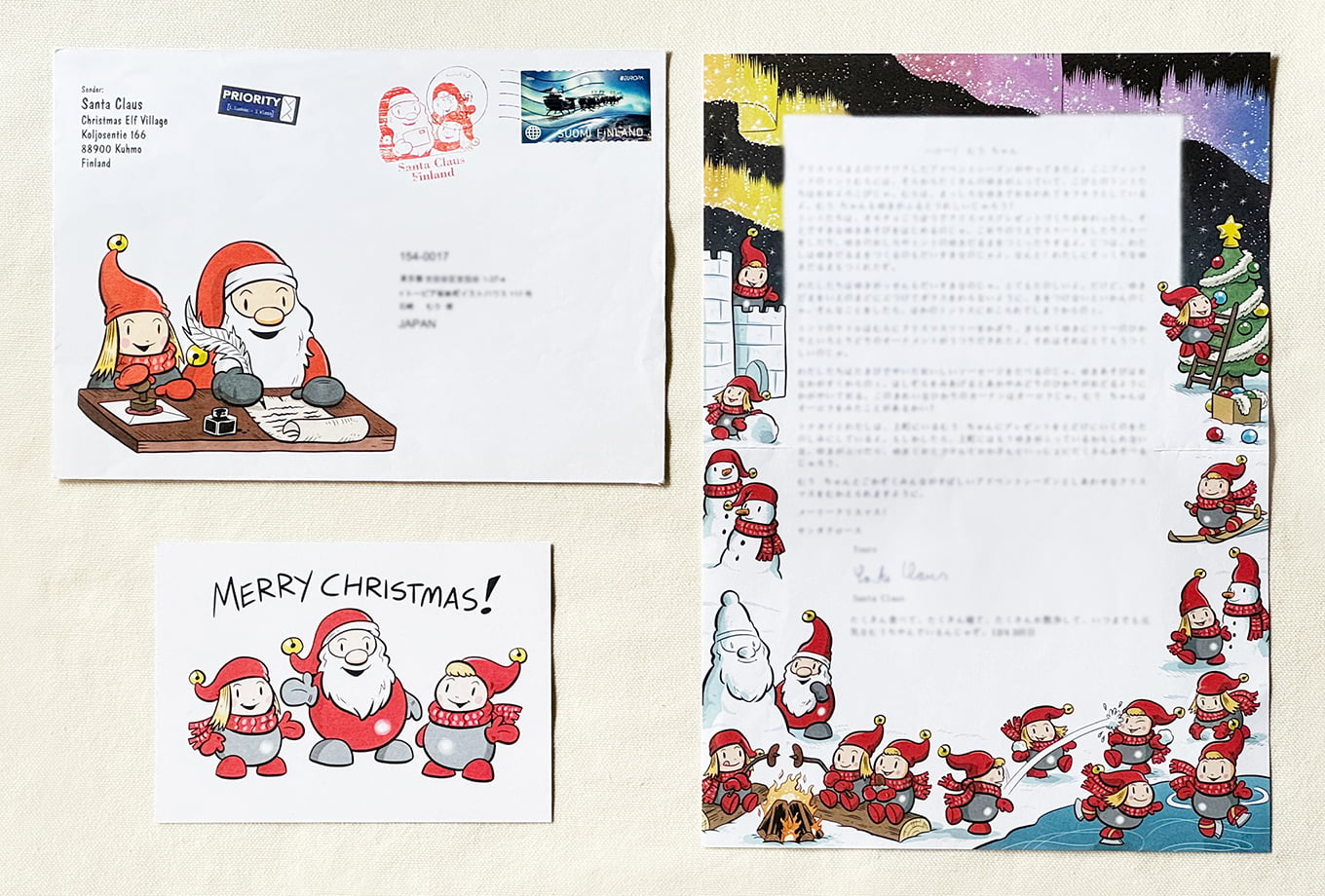 サインボードを持つサンタさんとプレゼントを持つ小人のトント – SANTA