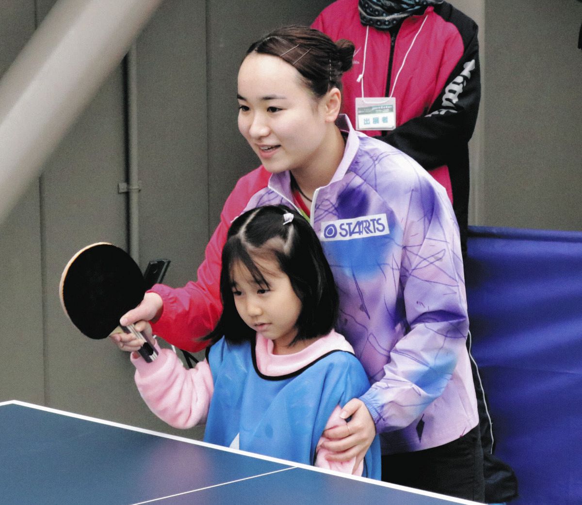 ◇伊藤美誠、ラケットに手をそえて卓球を教える【写真】：中日スポーツ